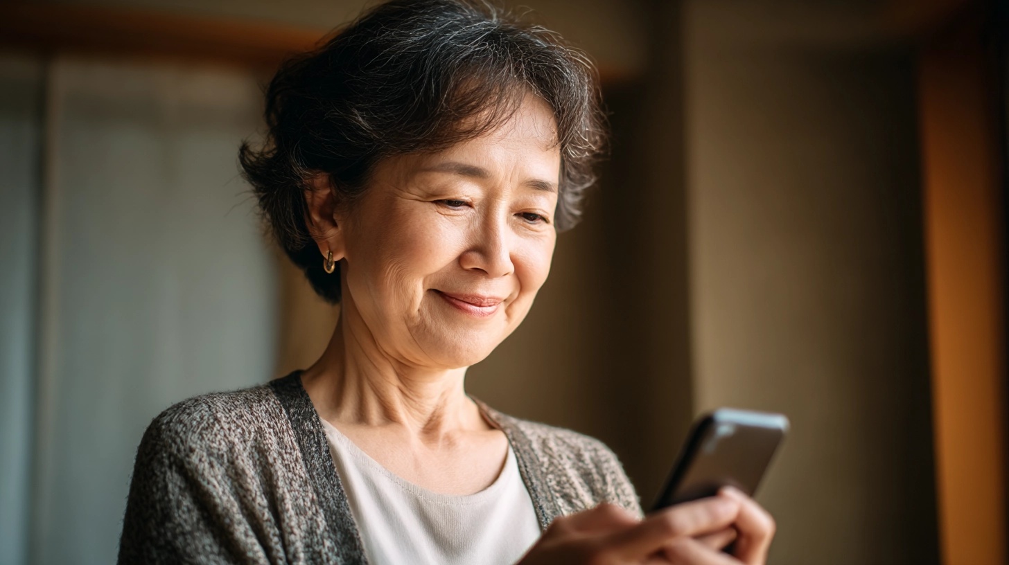 スマホ画面を見て安心した表情の高齢の母